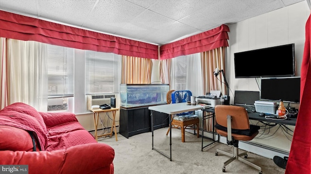 carpeted office space with a baseboard heating unit and a paneled ceiling