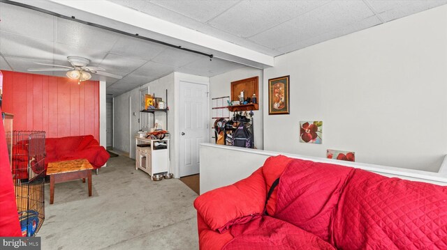 living room featuring ceiling fan and concrete flooring