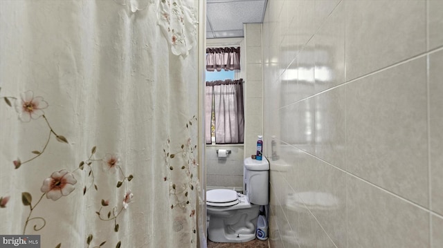 bathroom featuring tile walls, toilet, and a textured ceiling