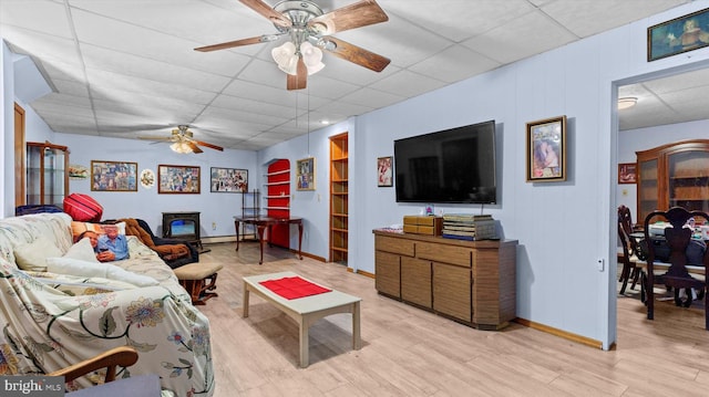 living room with light wood-type flooring, a paneled ceiling, and ceiling fan