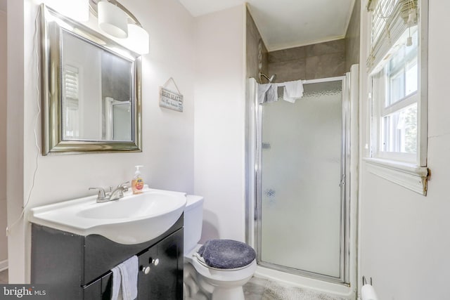 bathroom with a shower with shower door, toilet, and vanity