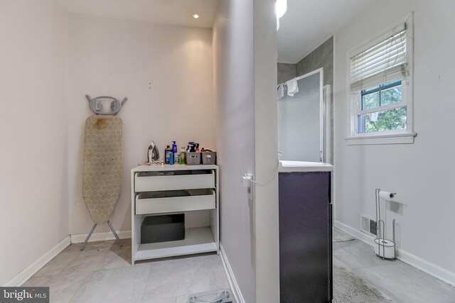 bathroom with vanity and a tile shower