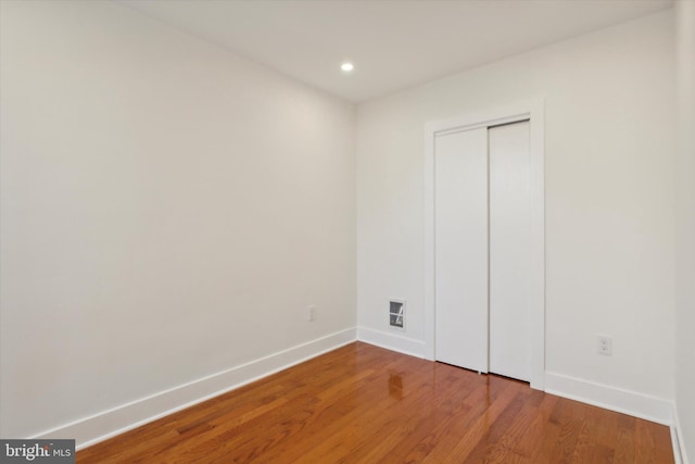 empty room featuring visible vents, recessed lighting, wood finished floors, and baseboards