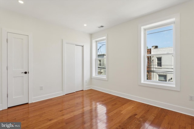 unfurnished bedroom featuring visible vents, recessed lighting, light wood-type flooring, and baseboards