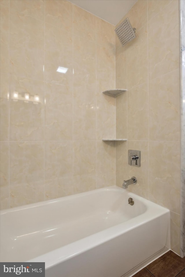 bathroom featuring tile patterned flooring, bathing tub / shower combination, and tile walls