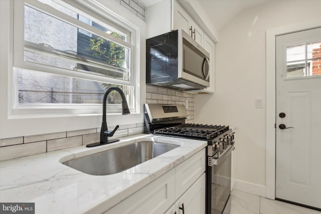 kitchen with white cabinetry, plenty of natural light, appliances with stainless steel finishes, and a sink