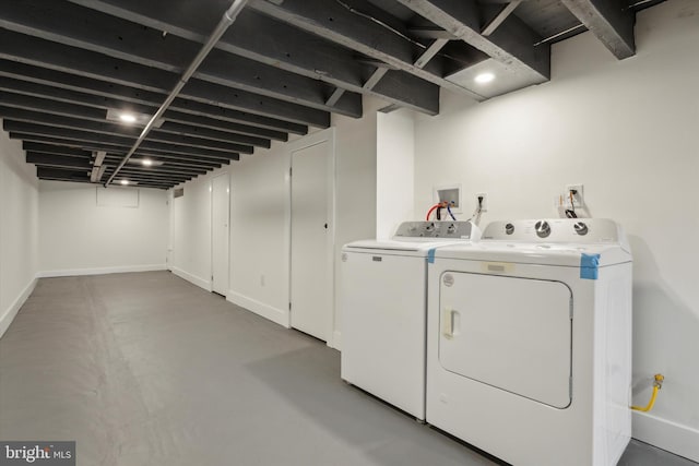 laundry area with baseboards, separate washer and dryer, and laundry area