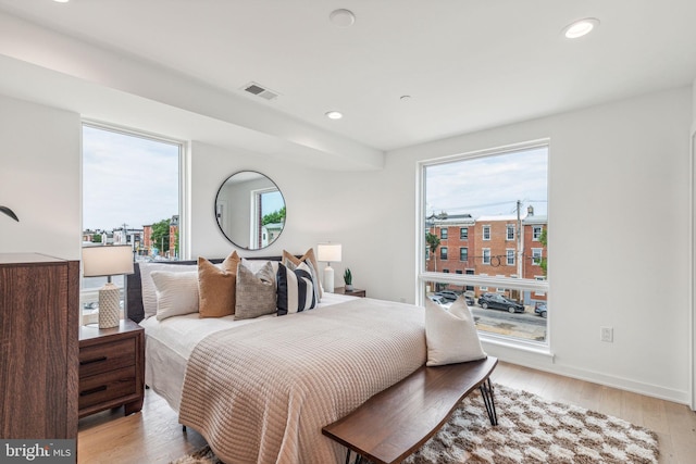 bedroom with light wood-type flooring and multiple windows