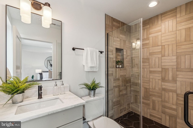 bathroom with tile patterned floors, vanity, walk in shower, and toilet