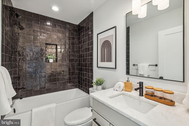 full bathroom featuring tiled shower / bath combo, vanity, and toilet