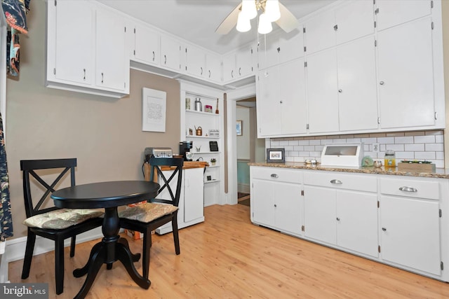 kitchen with light hardwood / wood-style floors, white cabinetry, tasteful backsplash, and ceiling fan