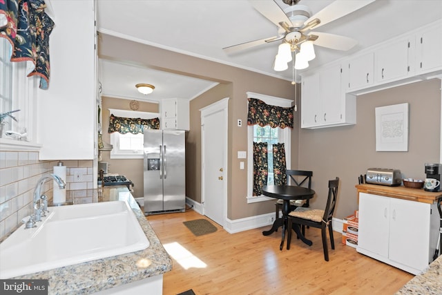 kitchen with white cabinets, stainless steel refrigerator with ice dispenser, and sink