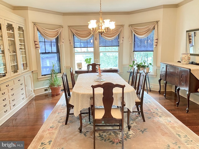 dining room featuring a chandelier, crown molding, and dark wood-type flooring