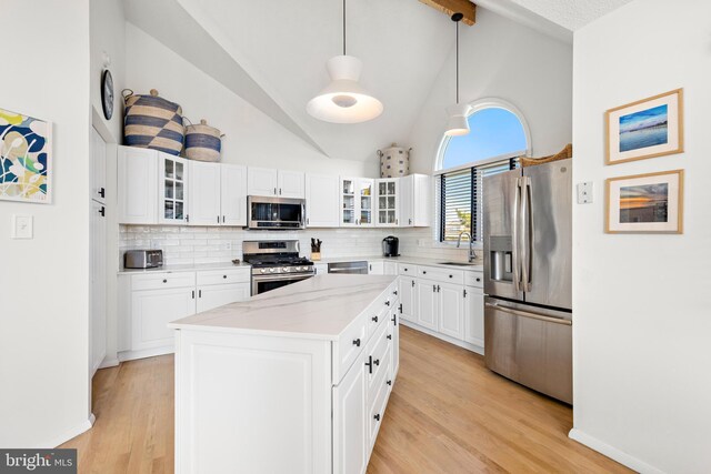 kitchen featuring pendant lighting, stainless steel appliances, white cabinetry, and light hardwood / wood-style floors