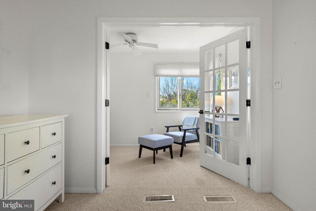 sitting room featuring ceiling fan and light colored carpet