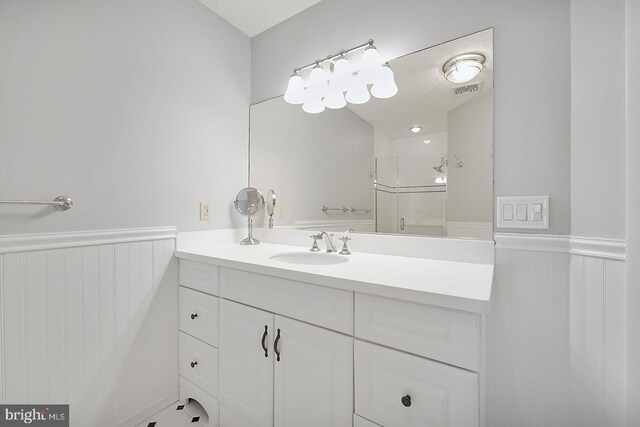 bathroom with walk in shower and vanity