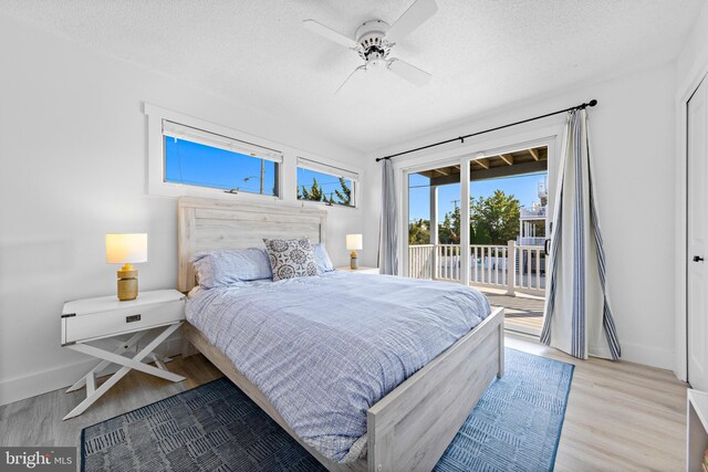 bedroom with access to outside, a textured ceiling, light hardwood / wood-style floors, and ceiling fan