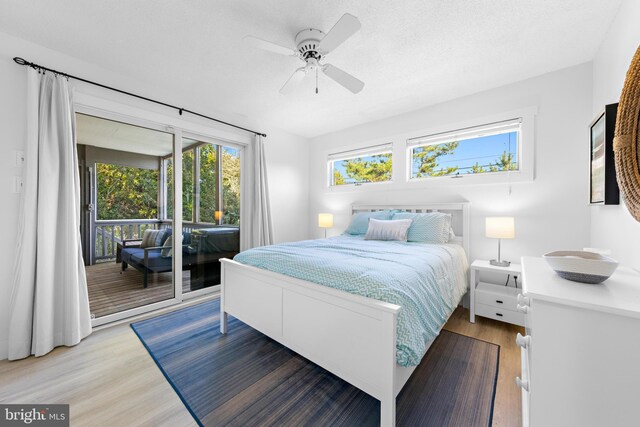 bedroom featuring ceiling fan, a textured ceiling, light hardwood / wood-style floors, and access to outside