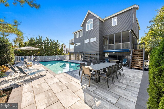 view of pool with a sunroom and a patio area