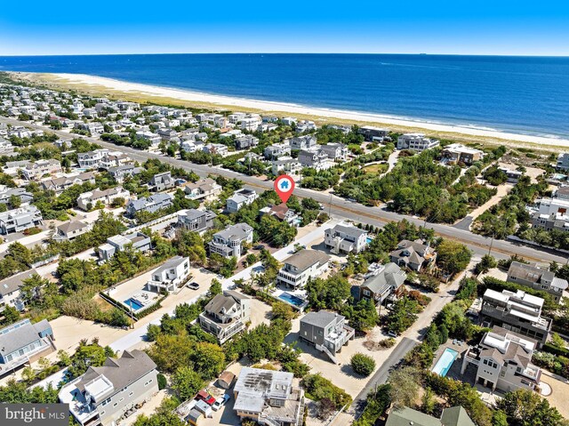 birds eye view of property featuring a water view and a beach view