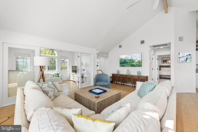 living room with beamed ceiling, ceiling fan, and light hardwood / wood-style flooring