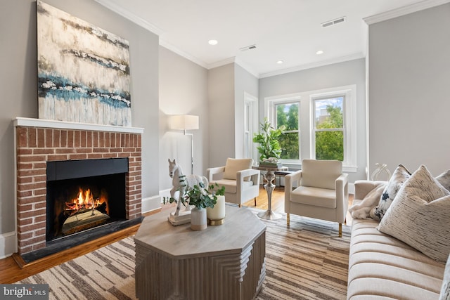 living room with wood-type flooring, ornamental molding, and a brick fireplace