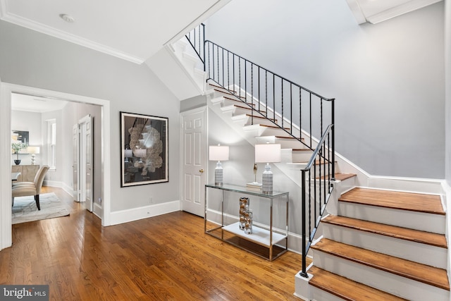 stairs with ornamental molding and hardwood / wood-style flooring