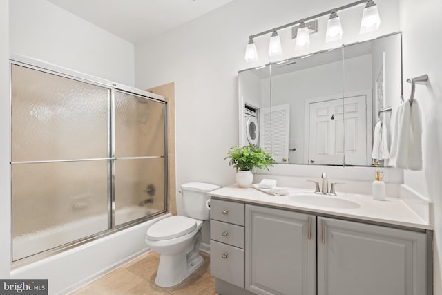 full bathroom featuring tile patterned flooring, toilet, combined bath / shower with glass door, and vanity