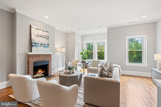 living room with light wood-type flooring, crown molding, and a brick fireplace