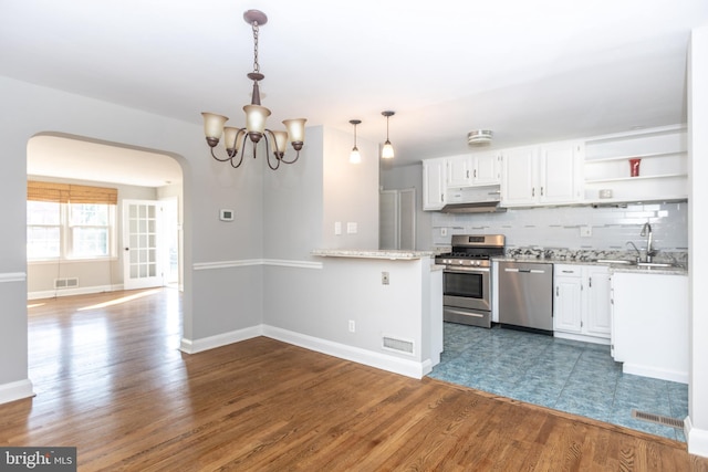 kitchen featuring appliances with stainless steel finishes, white cabinetry, dark wood-type flooring, and pendant lighting