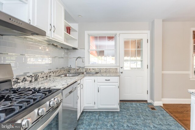 kitchen featuring light stone counters, sink, white cabinetry, appliances with stainless steel finishes, and dark hardwood / wood-style floors