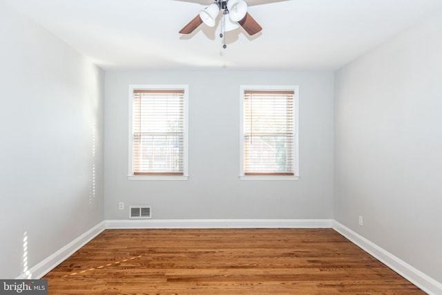 unfurnished room featuring a wealth of natural light, wood-type flooring, and ceiling fan