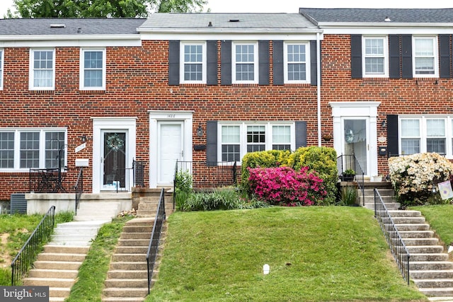 view of front of house featuring a front yard and central air condition unit