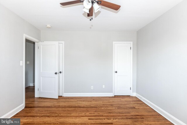 empty room with hardwood / wood-style floors and ceiling fan