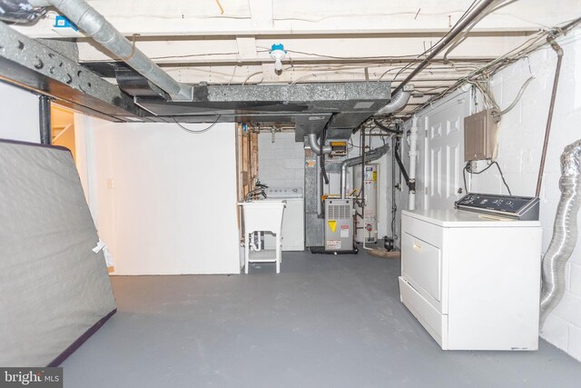 basement featuring gas water heater, heating unit, washer / dryer, and sink