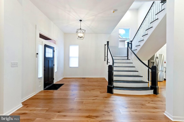 entryway with light hardwood / wood-style flooring and a chandelier