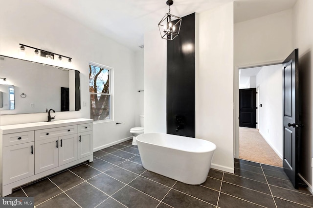 bathroom with a washtub, vanity, an inviting chandelier, tile patterned flooring, and toilet