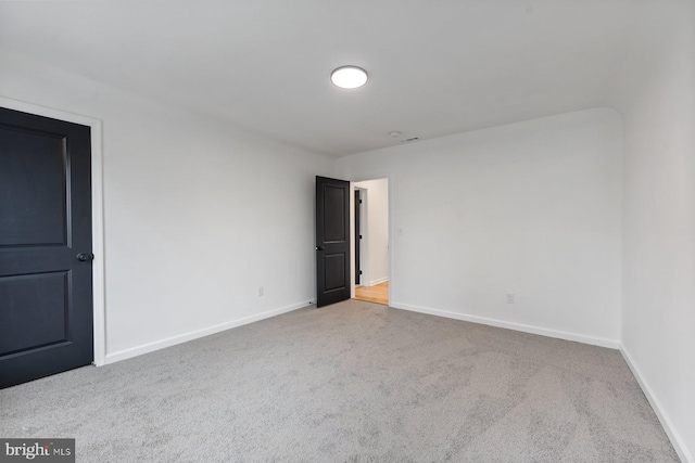 spare room featuring light colored carpet