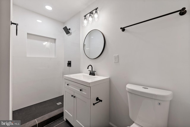 bathroom featuring vanity, toilet, and a shower