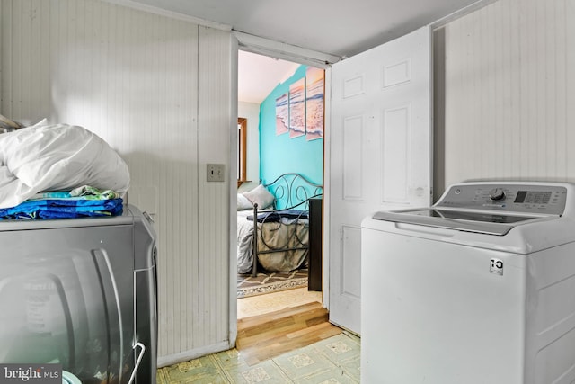 clothes washing area with light hardwood / wood-style floors