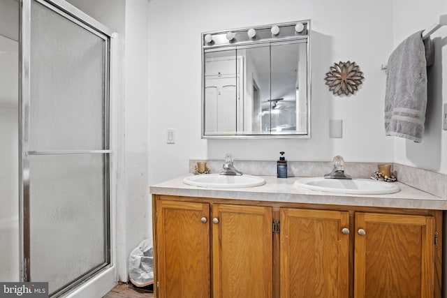 bathroom with vanity and a shower with shower door