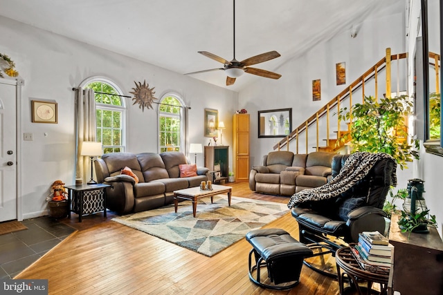 living room with high vaulted ceiling, ceiling fan, and hardwood / wood-style flooring