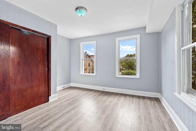 unfurnished bedroom with a closet, baseboards, and wood finished floors