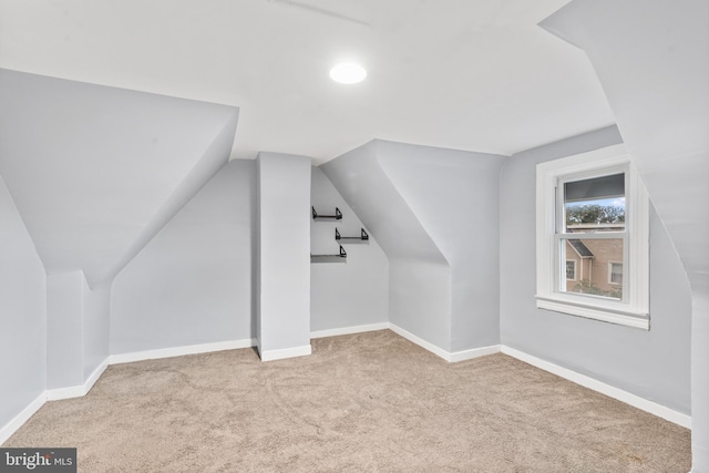 additional living space with baseboards, carpet, and lofted ceiling