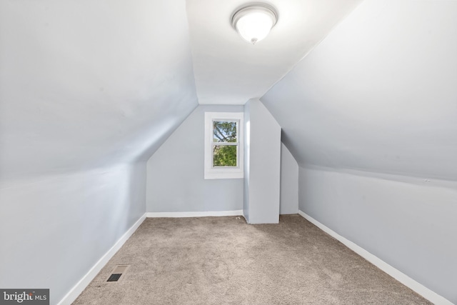 bonus room with carpet floors, lofted ceiling, visible vents, and baseboards