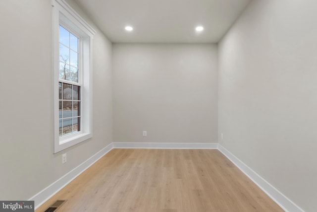 empty room featuring light wood-style floors, baseboards, visible vents, and recessed lighting