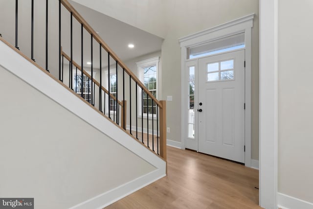 foyer featuring recessed lighting, stairway, baseboards, and wood finished floors