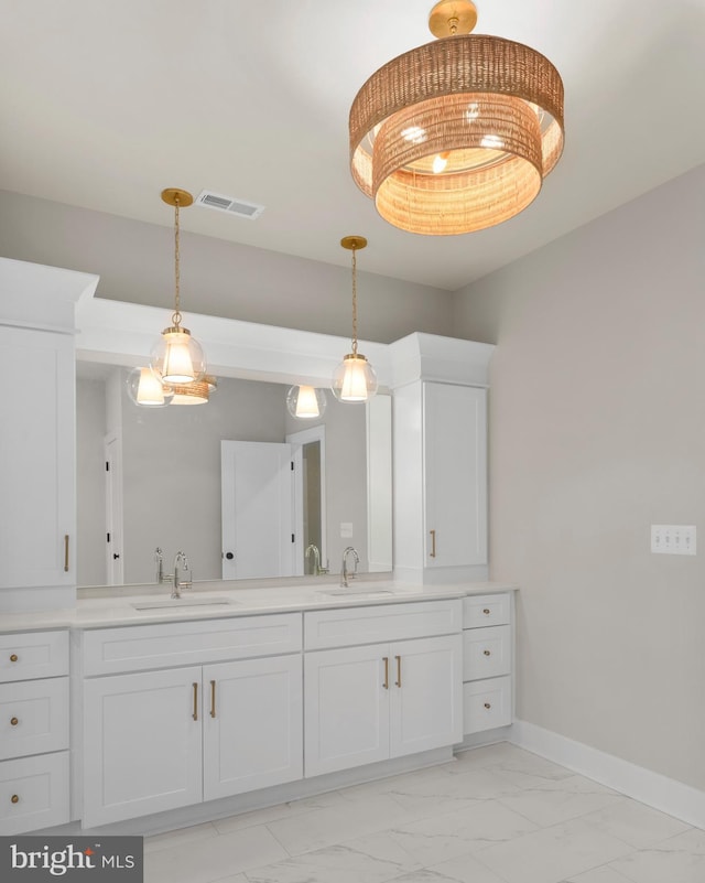 bathroom featuring marble finish floor, baseboards, visible vents, and a sink