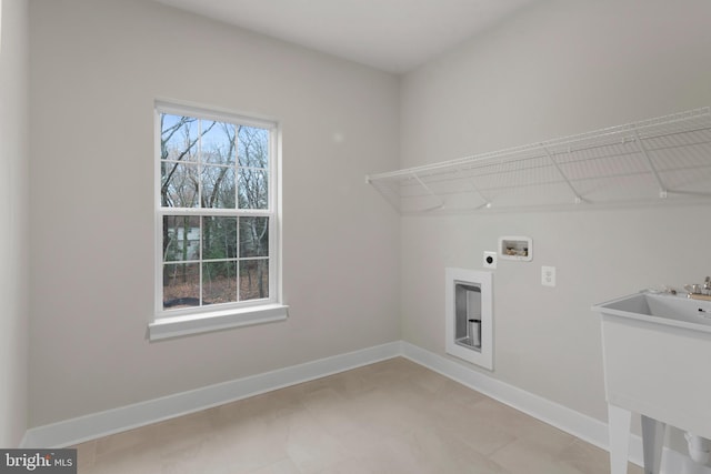 clothes washing area featuring hookup for an electric dryer, laundry area, washer hookup, a sink, and baseboards