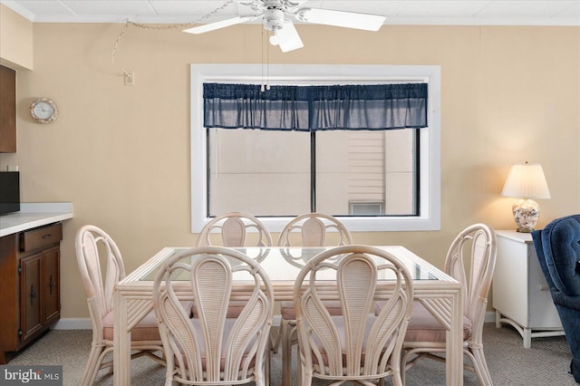 dining area with light carpet, ceiling fan, and crown molding